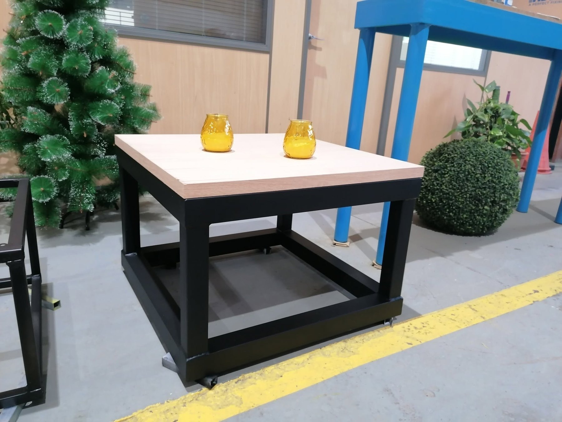 Mesa auxiliar Artelot con estructura negra, tablero de madera y ruedas